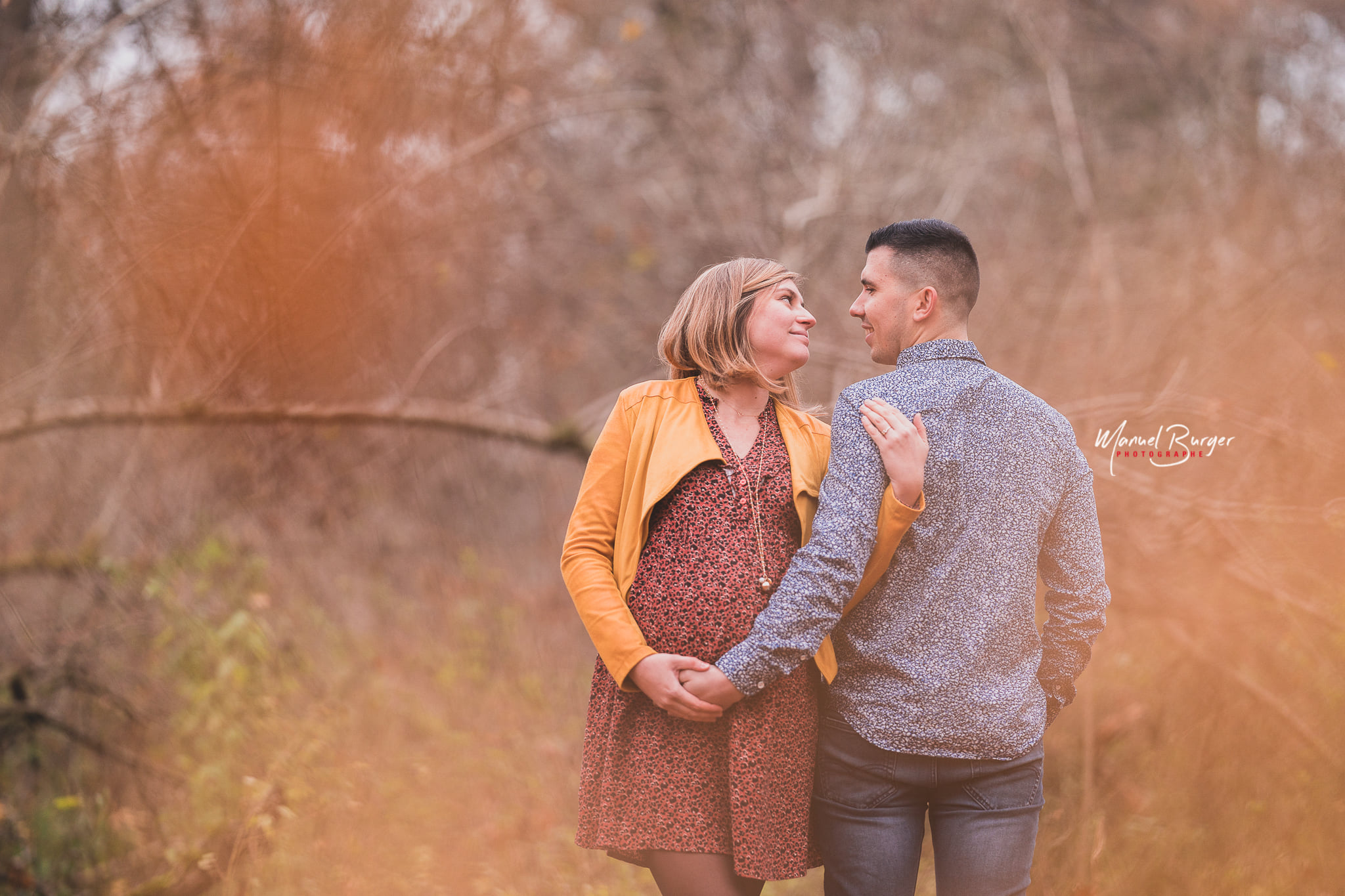 Portrait romantique d'un couple attendant un enfant au milieu des couleurs chaudes du Ried en automne, photographié à Sélestat 67600.
